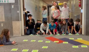 Students at CAL Elementary using the Sphero Indi students knelt down next to track